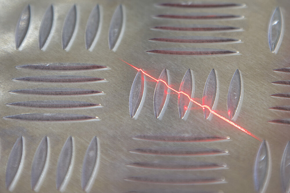 알루미늄 무늬 강판 위에 조사된 레이저 라인